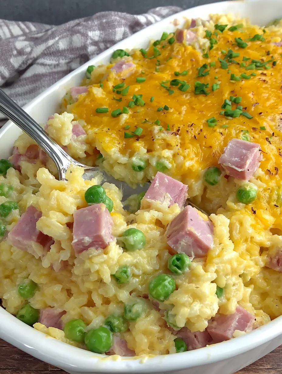 A white bowl filled with a cheesy ham and pea casserole.