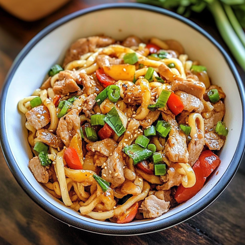 A plate packed with spicy pork noodles.