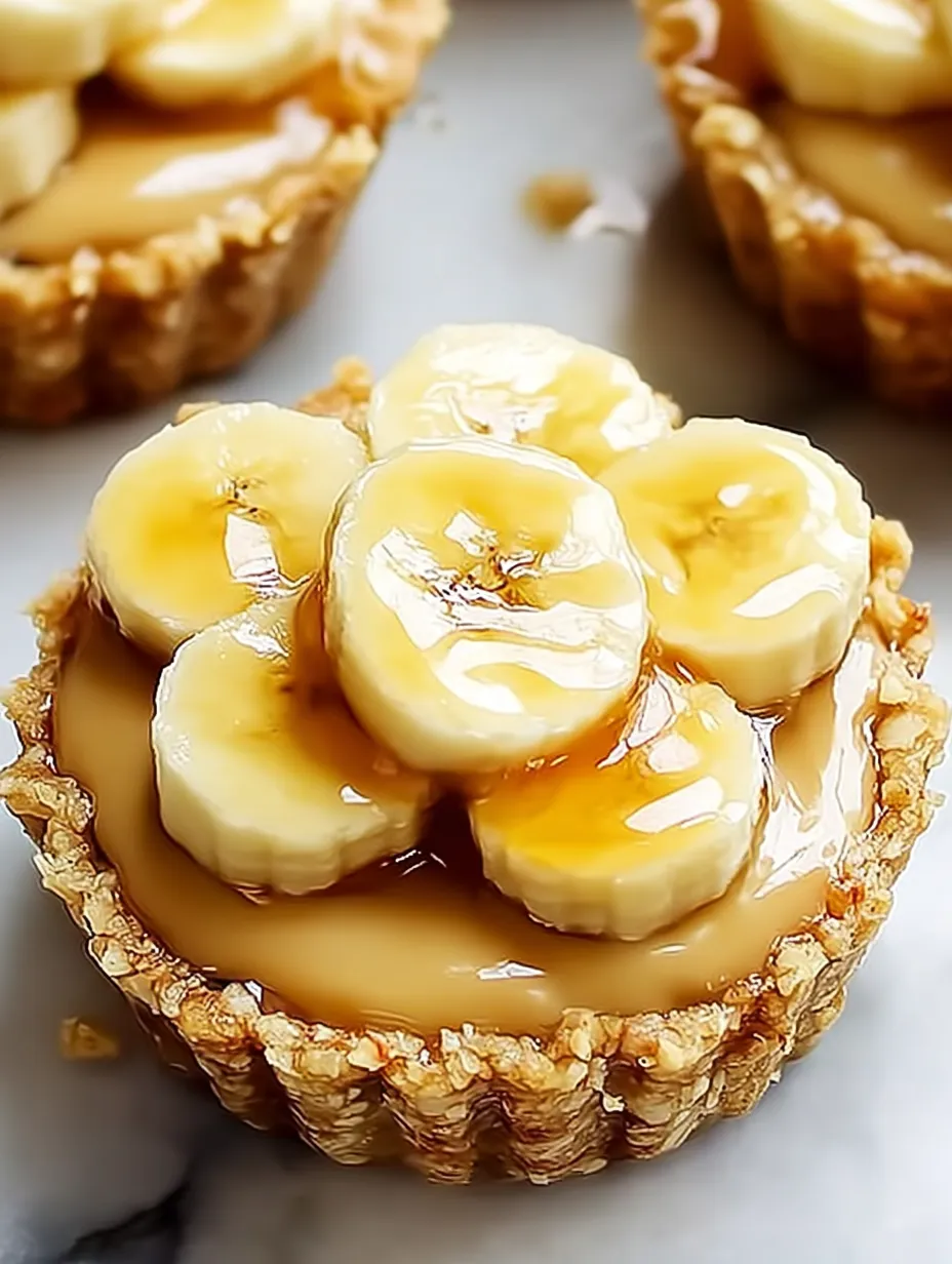 A close up of a banana cream pie with bananas on top.