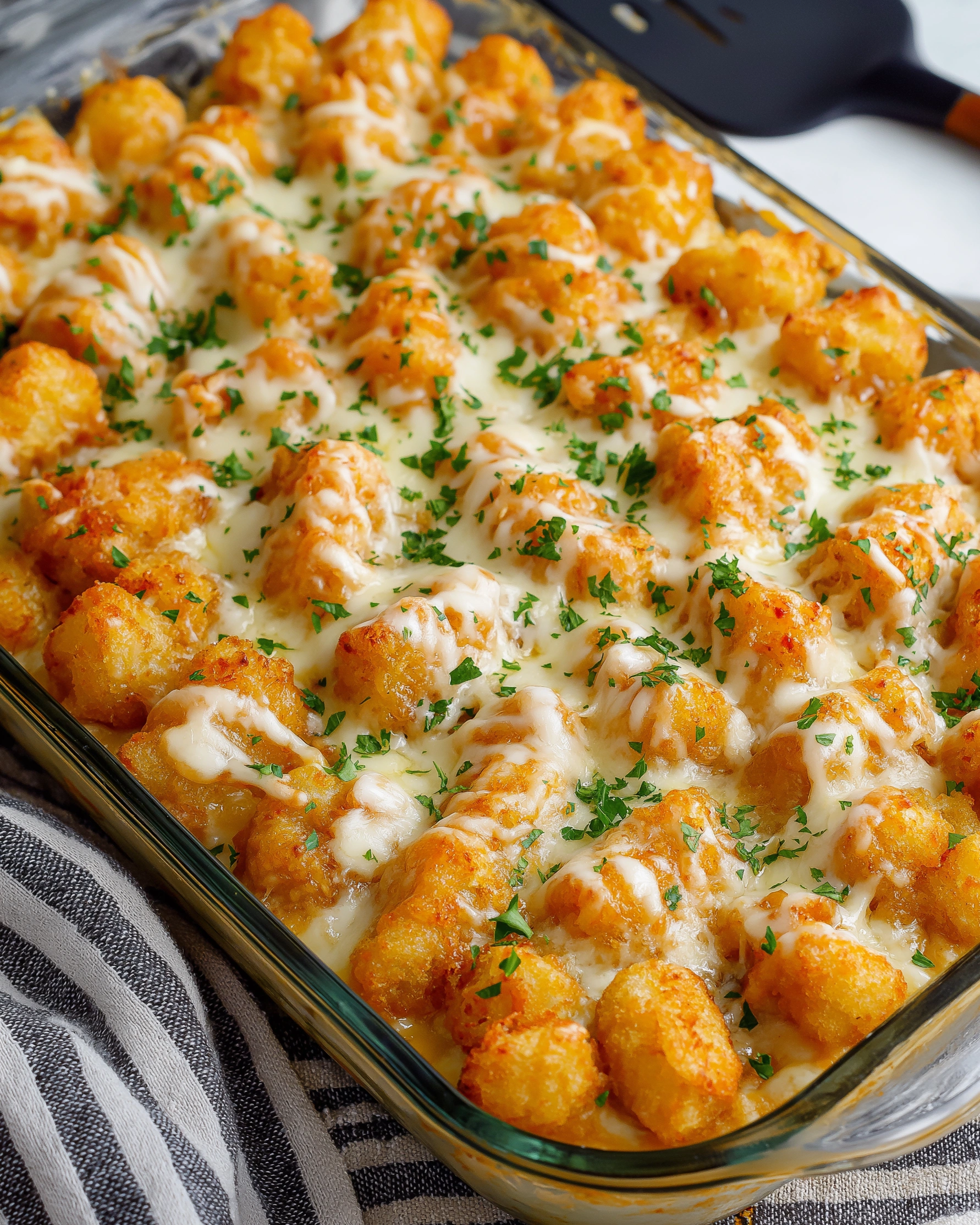 A casserole with chicken, Alfredo sauce, and tater tots.