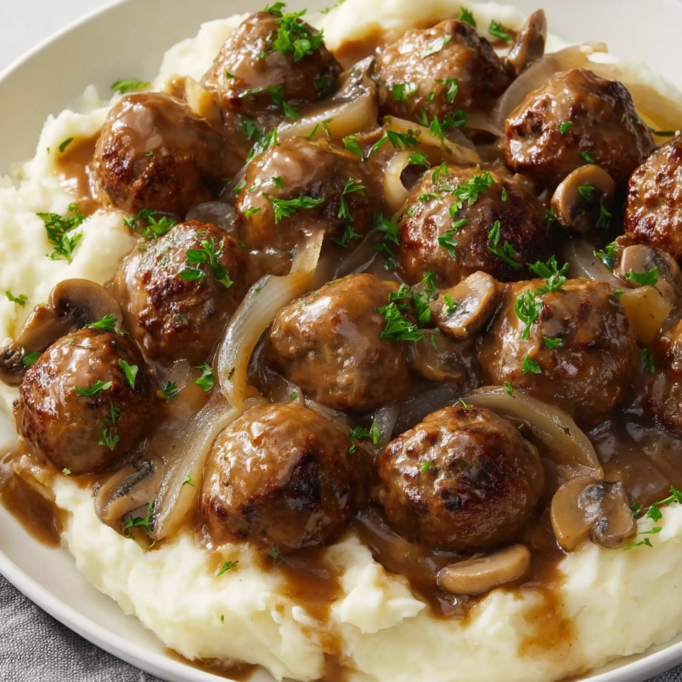 A plate of meatballs covered in gravy.