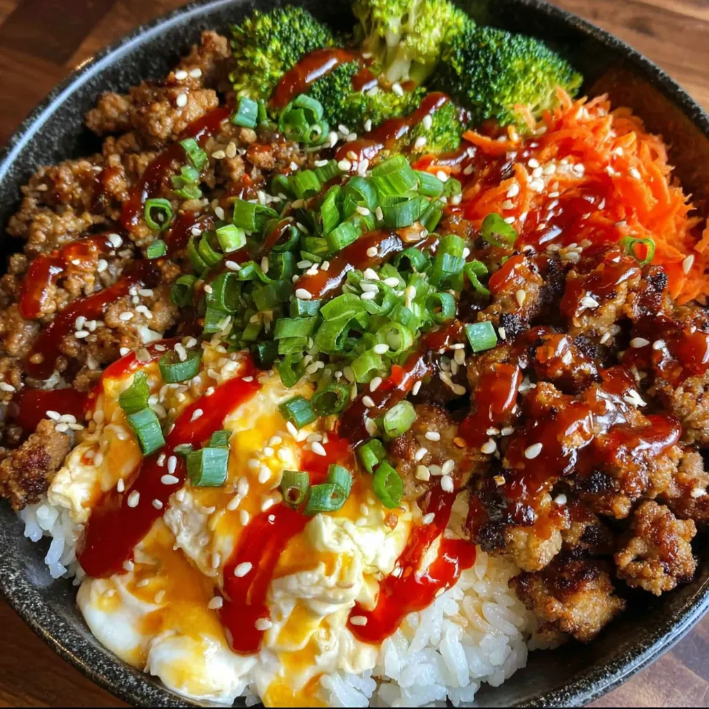 A bowl of food with rice, meat, and vegetables.