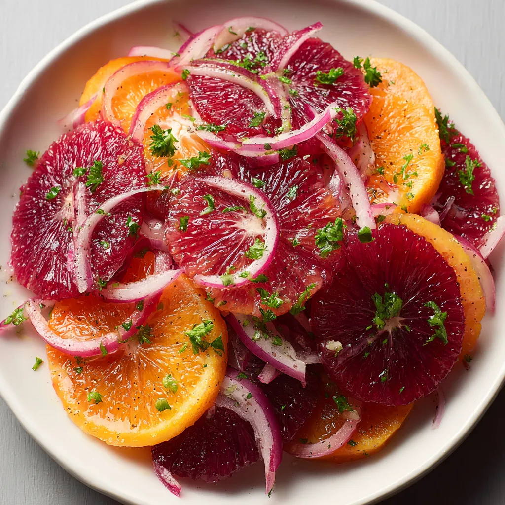 A plate of blood orange salad with fennel and pickled onion.