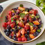 A bowl loaded with strawberries, blueberries, raspberries, and blackberries.
