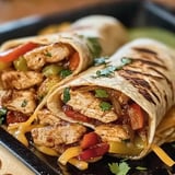 Some food on a plate with a burrito and a taco.