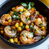 A bowl loaded with shrimp and sweet corn.