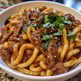 A plate filled with beef black pepper udon noodles.