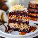 A piece of cake perched on a white plate.