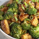 A bowl of chicken and broccoli with a brown sauce.