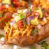 A dish of chicken enchilada stuffed sweet potatoes.